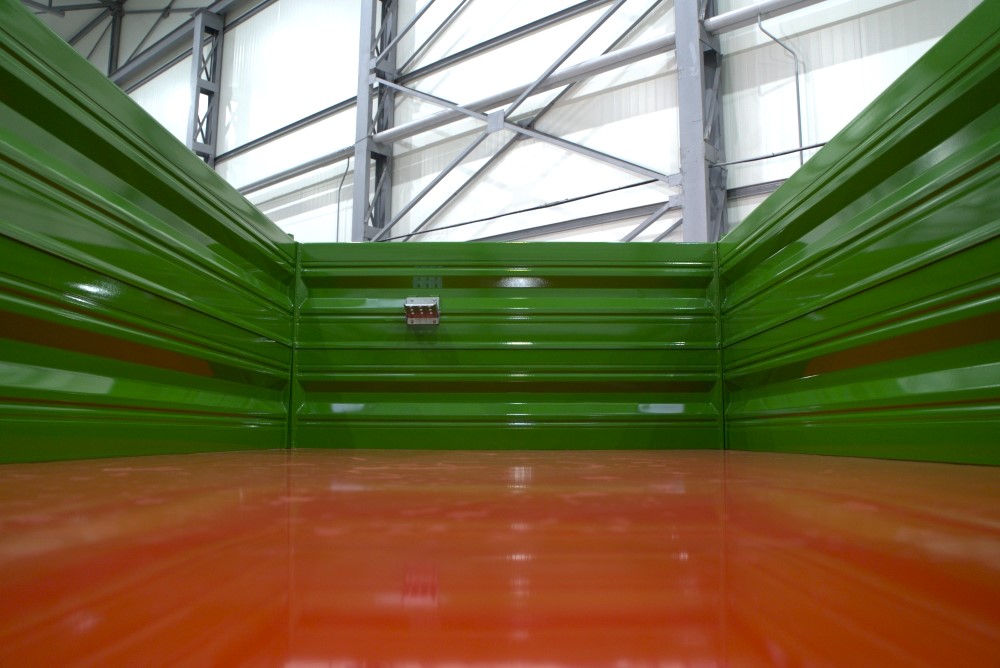 grüne Wände, industrieller Innenraum, Laderaum, Metallbleche, oranger Boden